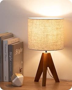 a wooden table with a lamp on top of it and some books next to it