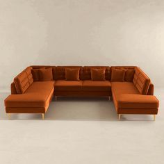 an orange sectional couch sitting on top of a white floor in front of a wall