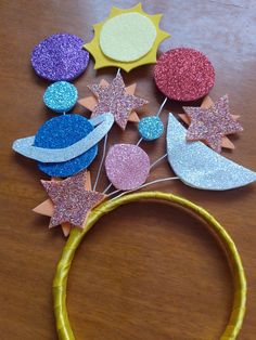 a wooden table topped with lots of different types of paper and glitter decorations on top of it