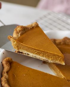 a slice of pumpkin pie being held by a knife