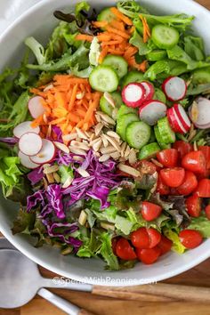 a salad with carrots, radishes, cucumbers and almonds