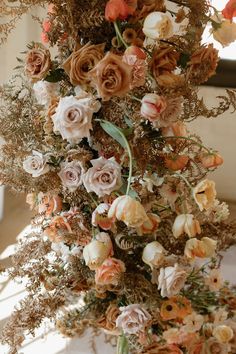 an arrangement of flowers is hanging from the ceiling