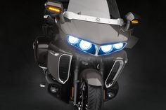 a motorcycle with its lights on in the dark