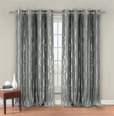 a living room with grey curtains and a chair