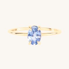 a yellow gold ring with an oval blue topazte