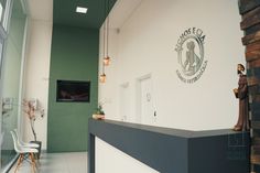 the interior of a medical office with statues on the wall and green doors in the background