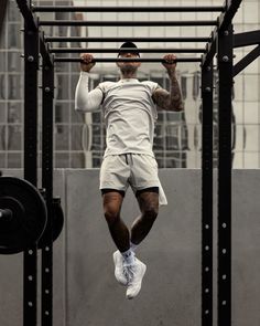 a man in white shirt and shorts doing pull ups