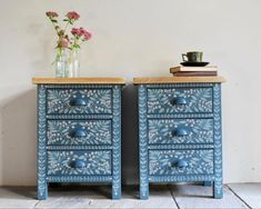 two blue painted drawers with flowers on top