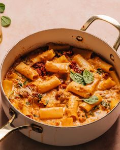 a pot filled with pasta and sauce on top of a table