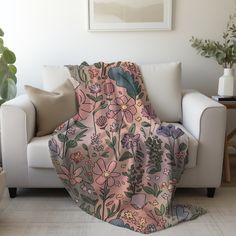 a living room with a white couch and a pink blanket on the back of it