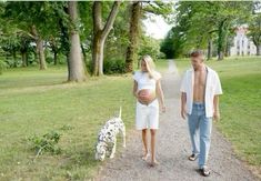 a man and woman walking down a path with a dalmatian dog next to them