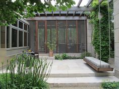 an outdoor patio with steps leading up to it and a bench in the foreground