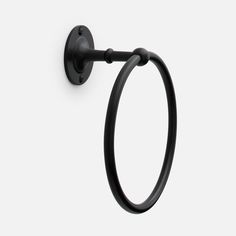 an image of a black towel ring on a white wall with the handle extended to it's left side