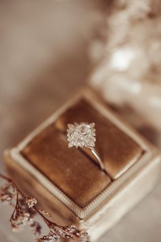 an engagement ring sitting on top of a box