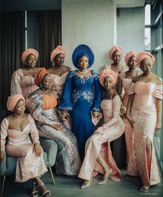 a group of women in dresses and turbans posing for a photo