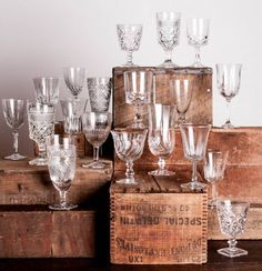 a bunch of wine glasses sitting on top of a wooden box next to each other