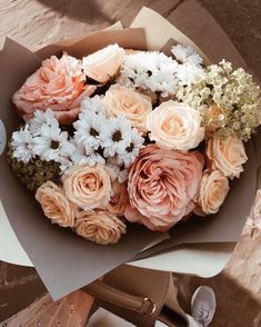 a bouquet of flowers sitting on top of a table next to a pair of shoes