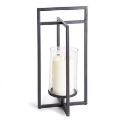 a candle holder with a glass and metal frame on the front, holding a lit candle