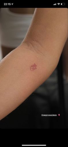 a person's arm with a small tattoo on the left side of their arm