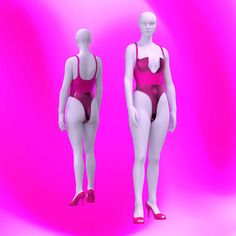 two female mannequins wearing red swimsuits against a pink background