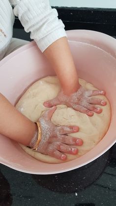 a person is kneading dough in a bowl on the stove top with their hands