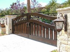 a wooden gate with wrought iron designs on it