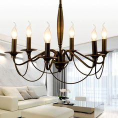 a chandelier with five lights hanging from it's center in a living room