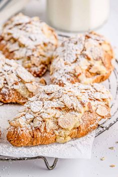 several pastries on a cooling rack next to a glass of milk