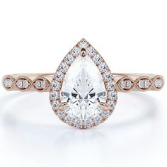 a rose gold engagement ring with a pear shaped diamond in the center and pave diamonds around it