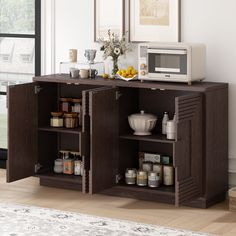 a microwave oven sitting on top of a wooden cabinet next to an open shelf filled with food