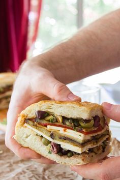 a person holding a sandwich in their hands