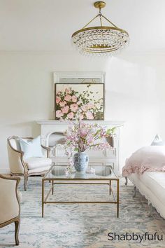 a living room filled with furniture and a chandelier hanging from the ceiling over a fireplace