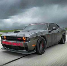 a gray car driving down a road under a cloudy sky with the word victory rally written on it