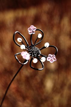 a metal flower with pink flowers on it