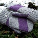 a pair of mittens sitting on top of snow covered ground next to grass and trees