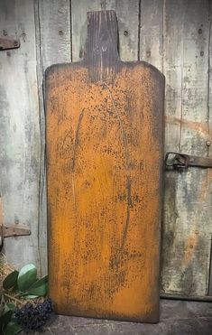 an orange cutting board sitting on top of a wooden table next to a planter