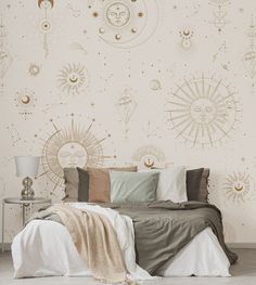 a large bed sitting in front of a wall with sun and moon designs on it