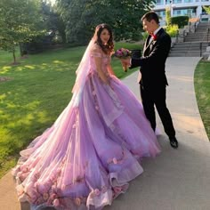 a man in a tuxedo standing next to a woman in a purple dress