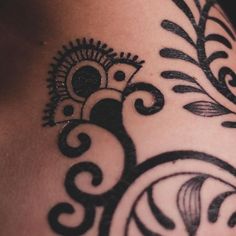 a close up of a tattoo design on the back of a woman's shoulder