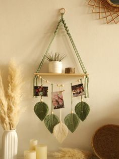 a wall hanging with pictures and photos on it next to candles, vases and other items