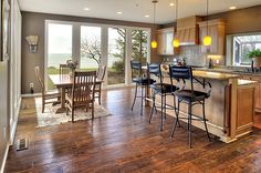 a large kitchen with wooden floors and lots of counter top space next to a dining room table