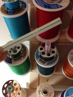 several spools of thread are hanging on the wall