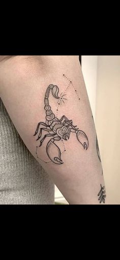 a woman's arm with a scorpion tattoo on the left side of her arm