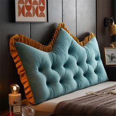 a bed with blue and yellow pillows on it's headboard in a bedroom