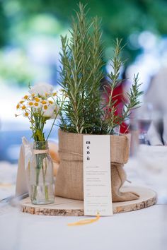 two small vases filled with flowers on top of a table