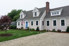 a large house with a flag on the front door and two windows in the back