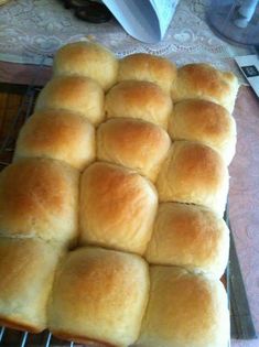 a bunch of bread rolls sitting on top of a cooling rack