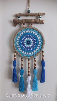 a blue and white dream catcher hanging on a wall