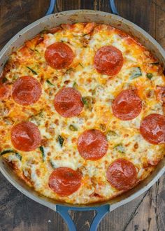 a pepperoni pizza sitting in a pan on top of a wooden table