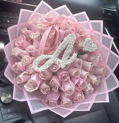 a bouquet of pink roses with the number 50 on it is sitting in a car